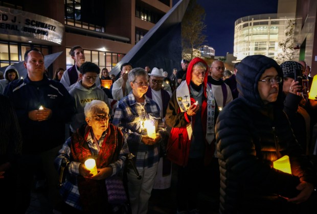 Multi-faith leaders gather for a candlelight vigil outside immigration court in downtown San Diego Thursday. (Sandy Huffaker / For The San Diego Union-Tribune)