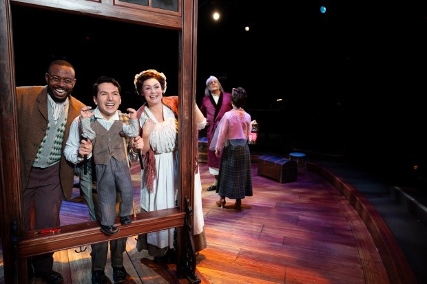 Josh Breckenridge as Bob Cratchit,left, Dan Rosales as Tiny Tim, and Jacque Wilke as Mrs. Cratchit in a scene from the 2023 staging of The Old Globe's "Ebenezer Scrooge's BIG San Diego Christmas Show." (Rich Soublet II)