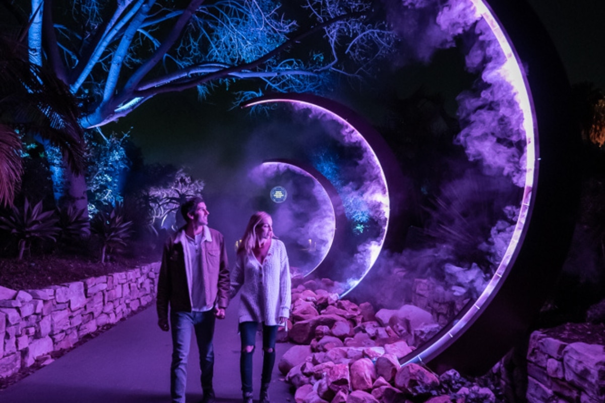 A couple walks past light displays