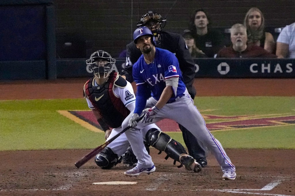 Texas Rangers second baseman Marcus Semien (2) hits a home run against the Arizona Diamondbacks.