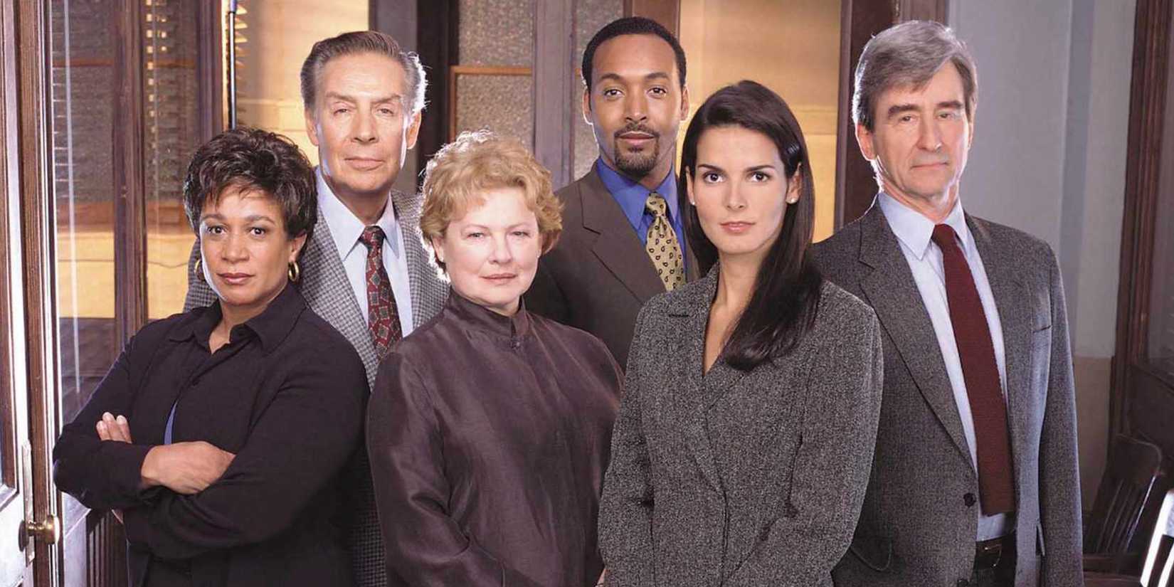 The original Law and Order cast standing together looking at the camera