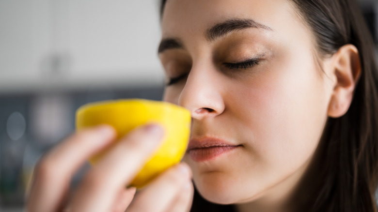 woman holding lemon up to nose