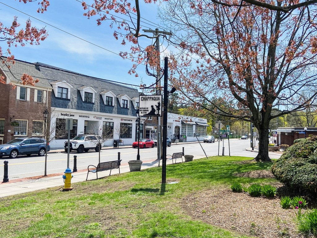 View of downtown shops in Chappaqua, New York, with a commemorative plaque stating "Chappaqua Settled by the Quakers in 1730."