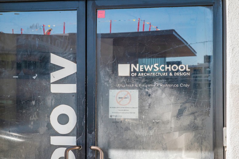 The glass double doors of what once was the NewSchool of Architecture look worn and dirty with part of the name fading.