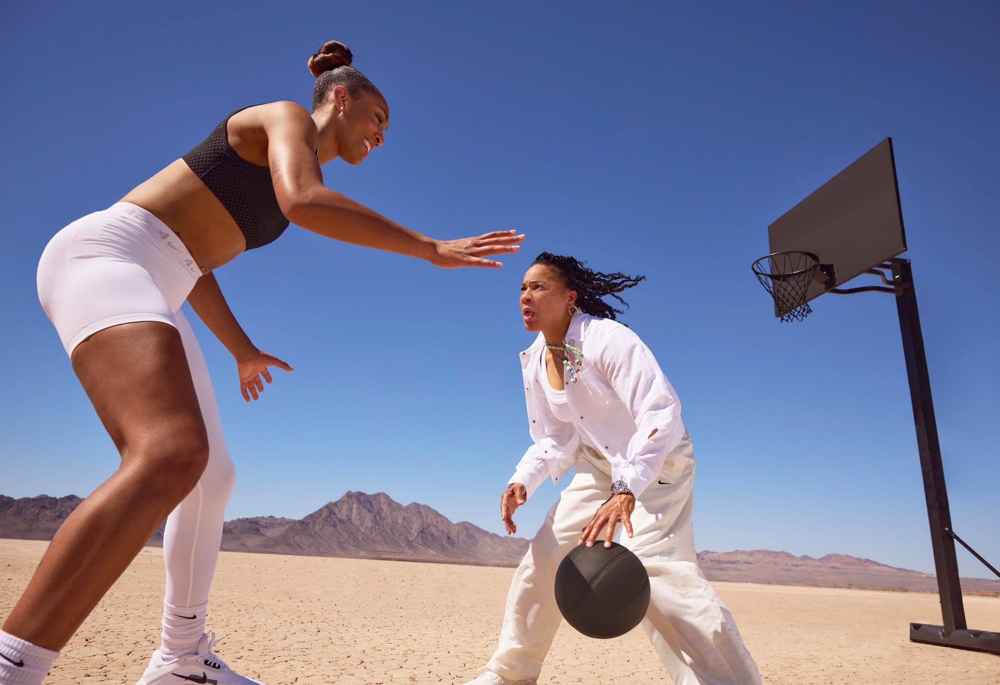 a’ja wilson and dawn staley. on a’ja: nike sports bra\, leggings\, socks\, and sneakers. on dawn: vince jacket\, calvin klein tank\, nike pants and sneakers\, zappos.com.