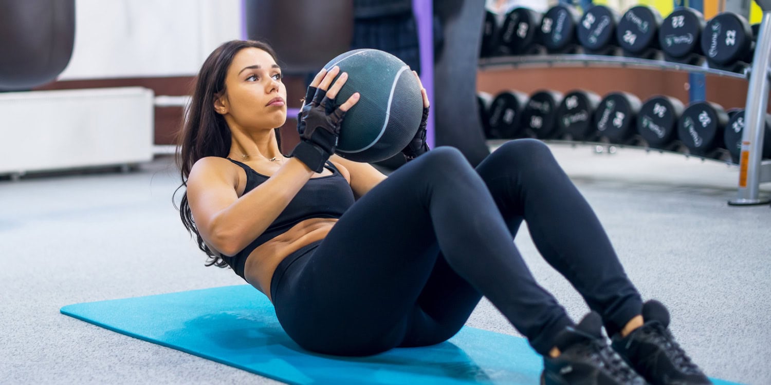 Woman exercising with medicine ball in gym, strength training, fitness, workout, healthy lifestyle, physical fitness, sports training, gym equipment, athleticism, fitness motivation.