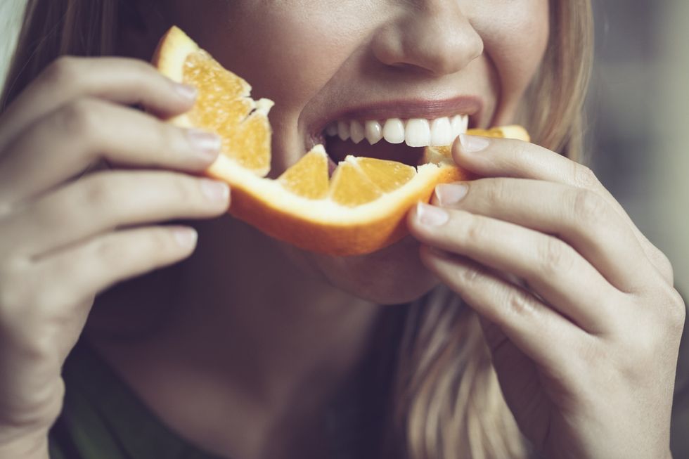 Woman eating orange