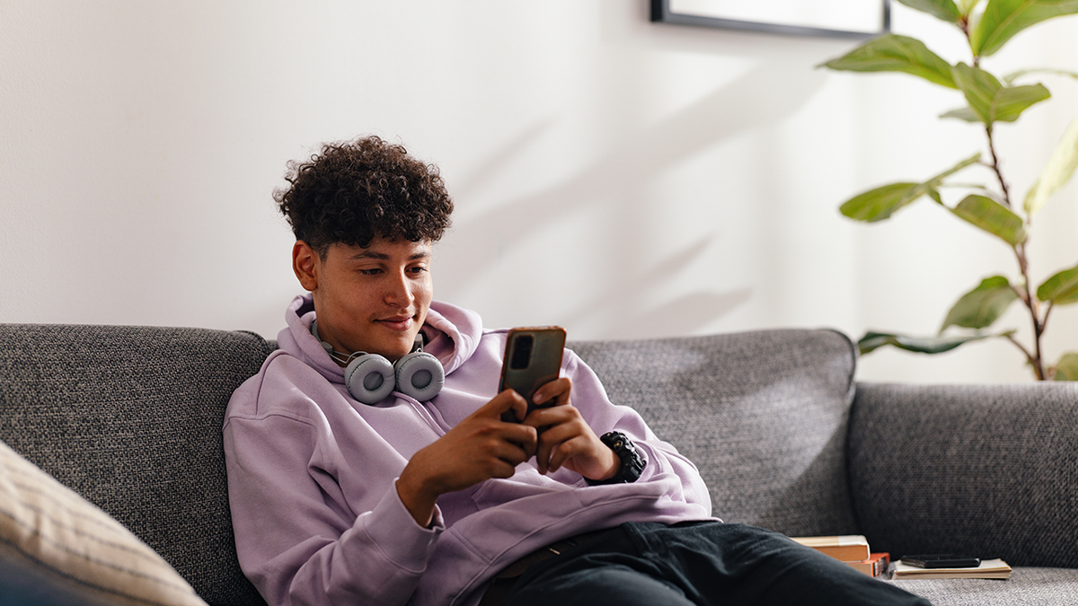 Young man smiling while looking at phone