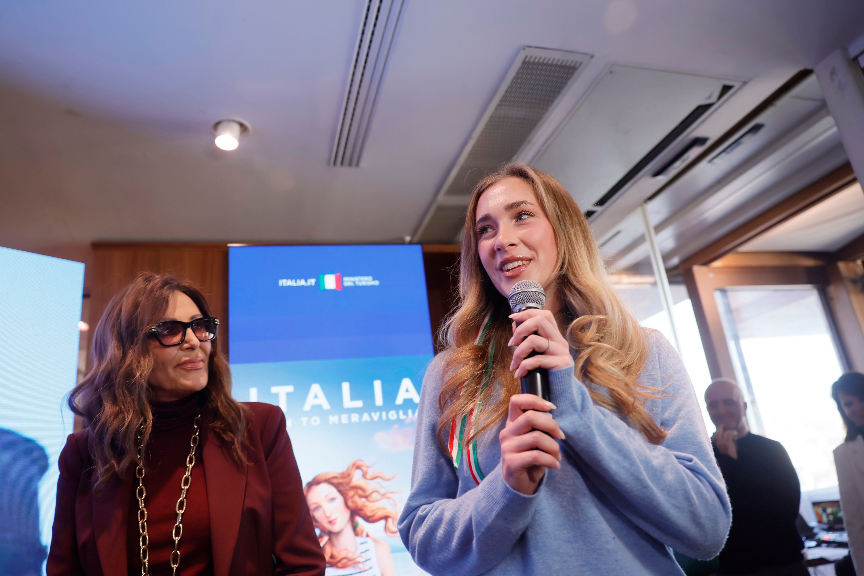 Daniela Santanchè and a blonde woman present the "Welcome to Meraviglia" campaign.