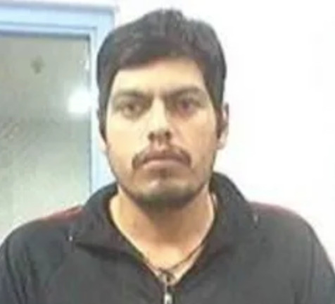 A portrait of a dark-haired man in a black shirt.