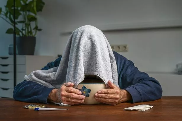 Someone with a cold over a bowl of steam