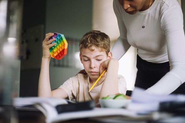 Woman helping a boy with his homework, school, class work