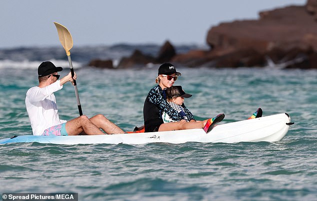 For his part, the father-of-two, 44, was clad in a long-sleeved white T-shirt, black sunglasses, and pastel blue and pink swim trunks