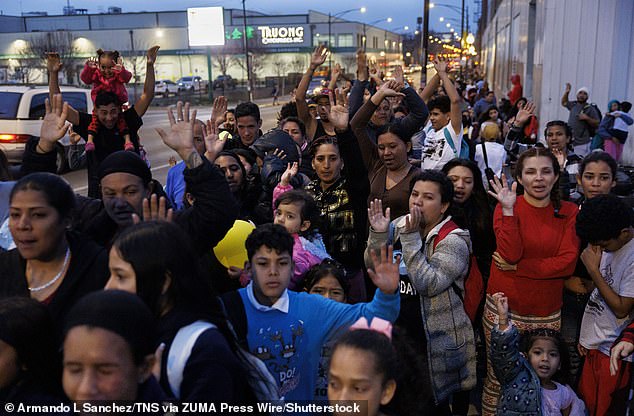 Tens of thousands of migrants have flocked to Chicago since 2022 (pictured: Migrants at a religious gathering outside of a Chicago shelter in 2024)