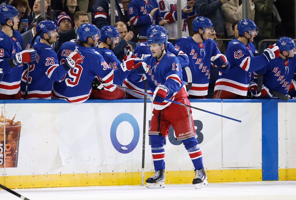 New York Rangers left wing Alexis Lafrenière (13) is greeted by his teammates on the bench after scoring a goal during the second period.