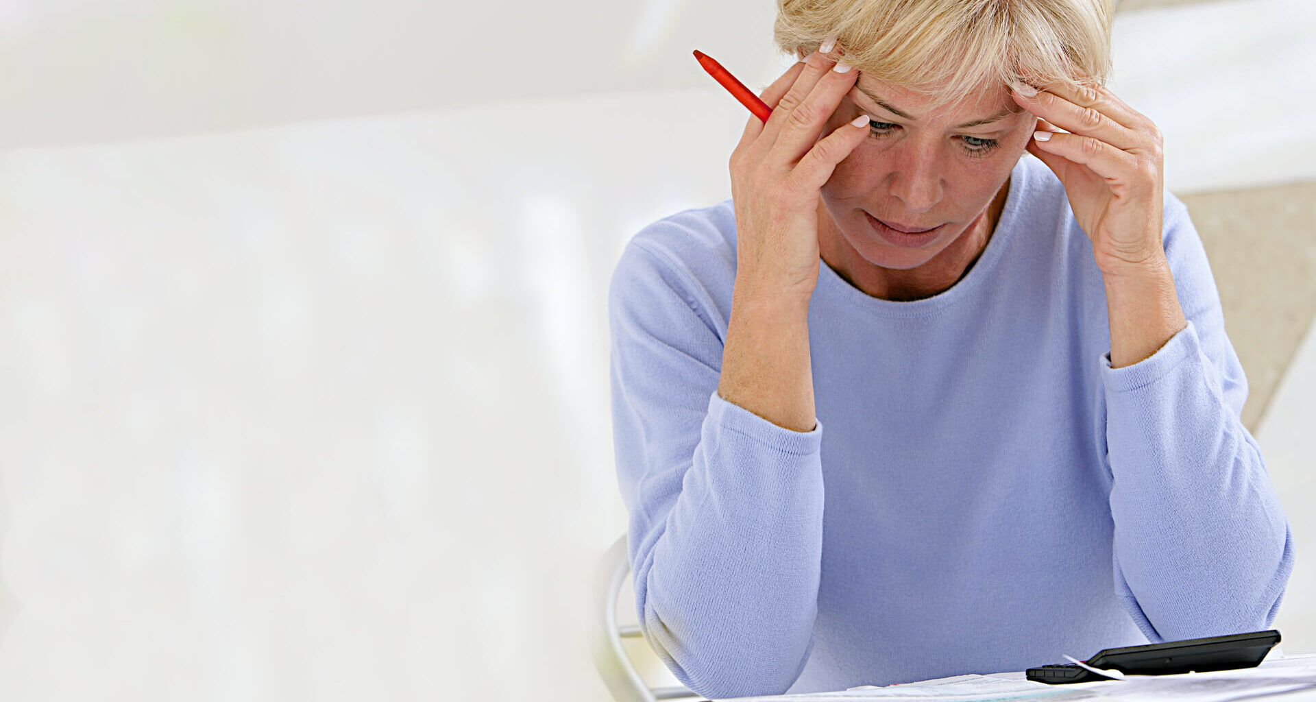 Confused woman sitting at home making calculations