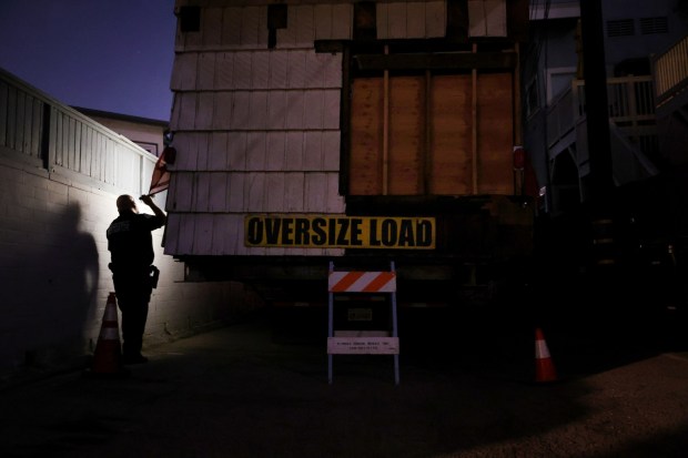 David Orozco, an investigation officer for the city of Los Angeles, inspects a section of a 1910 Craftsman home in Los Feliz until crews can transport it to an empty lot in Altadena, on Monday, Aug. 5, 2025. The home is part of the Historic House Relocation Project, which takes homes slated for demolition to burned out lots from the Eaton Fire in Altadena. (Photo by Trevor Stamp, Contributing Photographer)