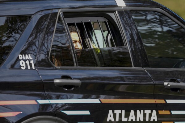 Derrick Groves, the last escapee from the New Orleans jailbreak in May, sits in a police vehicle after being taken into custody by U.S. Marshals and Atlanta police at a southwest Atlanta home, Wednesday, Oct. 8, 2025. (Ben Hendren/Atlanta Journal-Constitution via AP)
