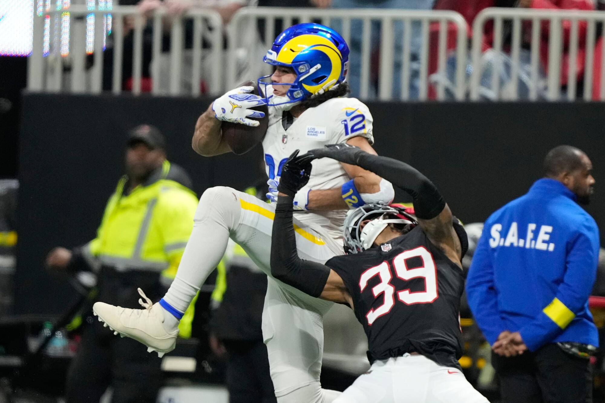 Rams wide receiver Puka Nacua pulls in a long pass over Atlanta Falcons cornerback C.J. Henderson in the first half Monday.