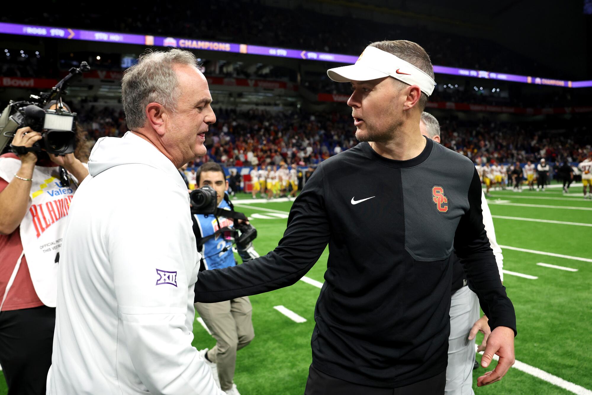 USC coach Lincoln Riley, right, greets TCU coach Sonny Dykes after the Trojans' overtime loss in the Alamo Bowl.