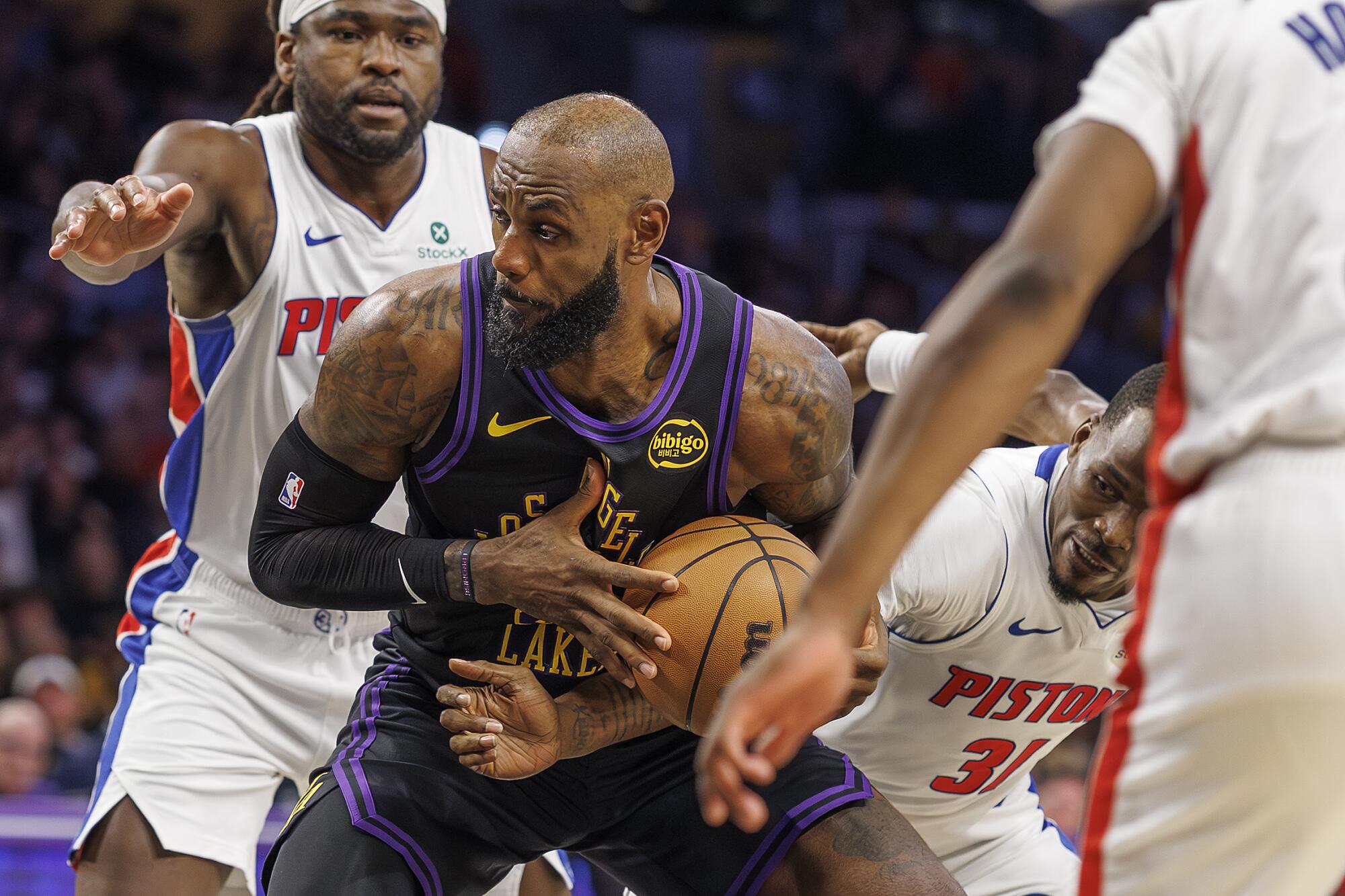 Lakers star LeBron James is fouled by Detroit Pistons guard Javonte Green (31) in the first half Tuesday.