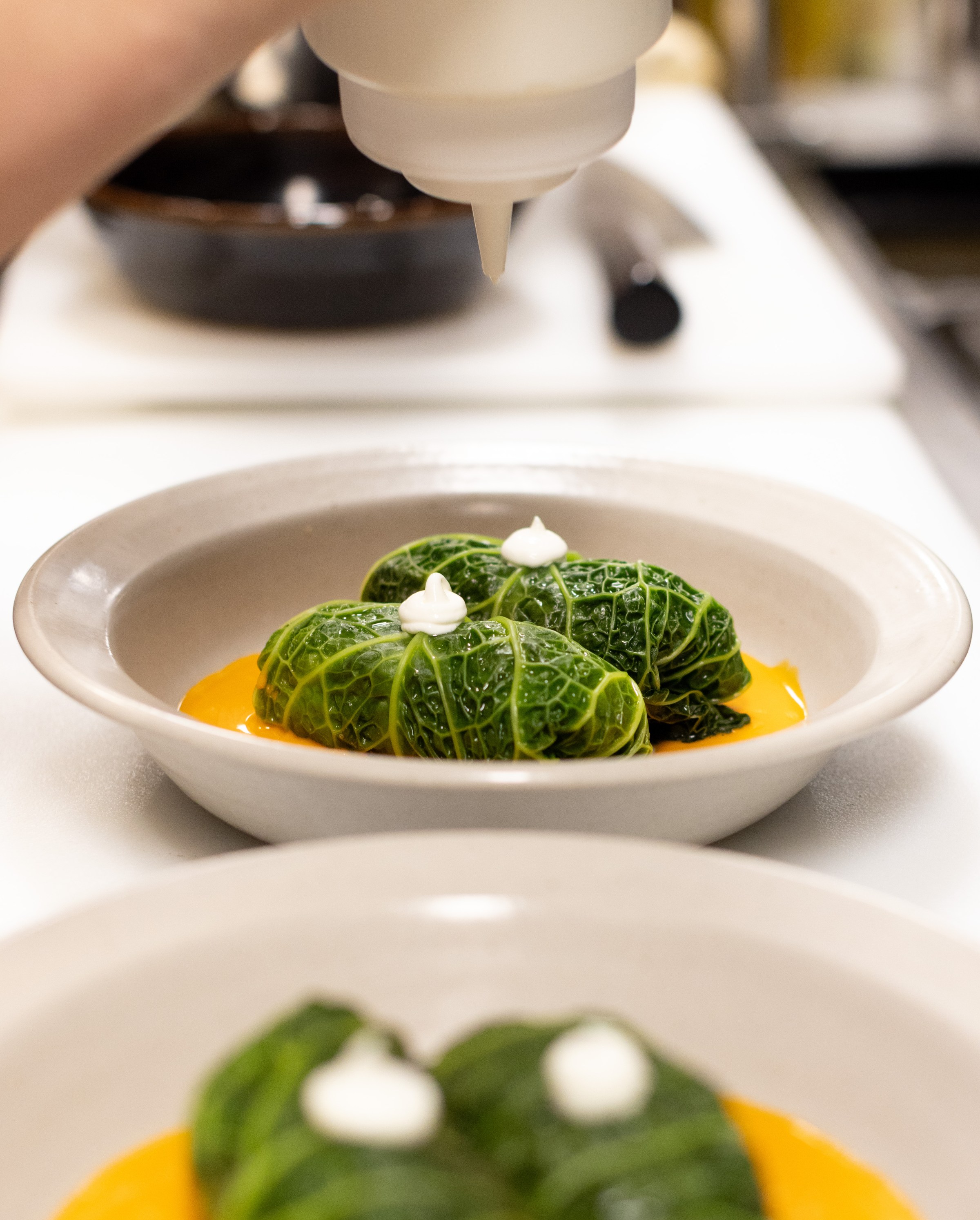 Stuffed cabbage in the kitchen in a bed of yellow sauce at Little Fish.