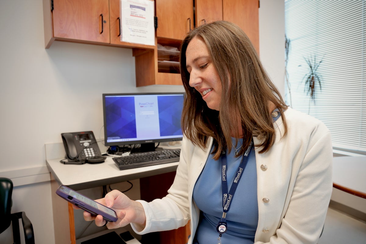 Corinne Rhodes looks at her phone