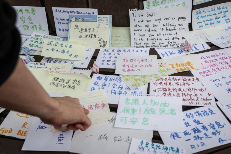 People leave notes with well-wishes for those affected by the deadly fire at the Wang Fuk Court housing complex, in Tai Po, Hong Kong, China, November 30, 2025. REUTERS/Tyrone Siu SEARCH "HONG KONG FIRE PICTURE" FOR THIS STORY. SEARCH "WIDER IMAGE" FOR ALL STORIES.