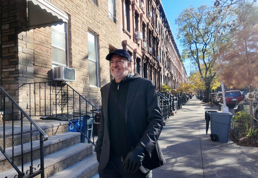 Former New York City Mayor Bill de Blasio walking on a sidewalk.