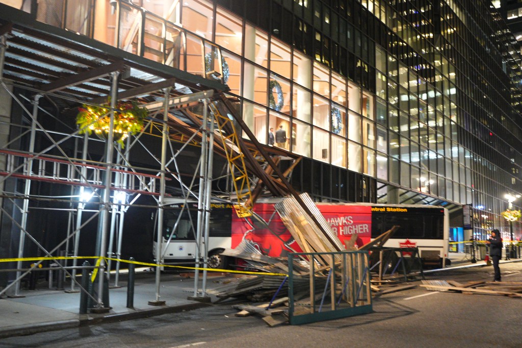 A bus that crashed into building scaffolding near Grand Central Station, with debris scattered around.