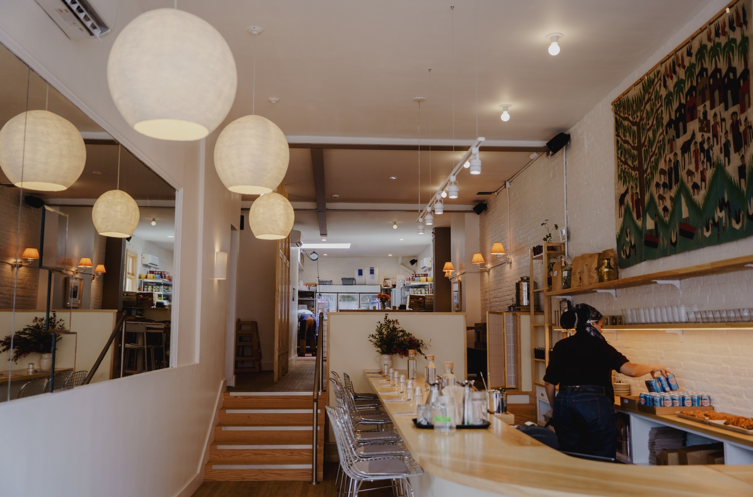 A restaurant counter leading to stairs to a dining room.