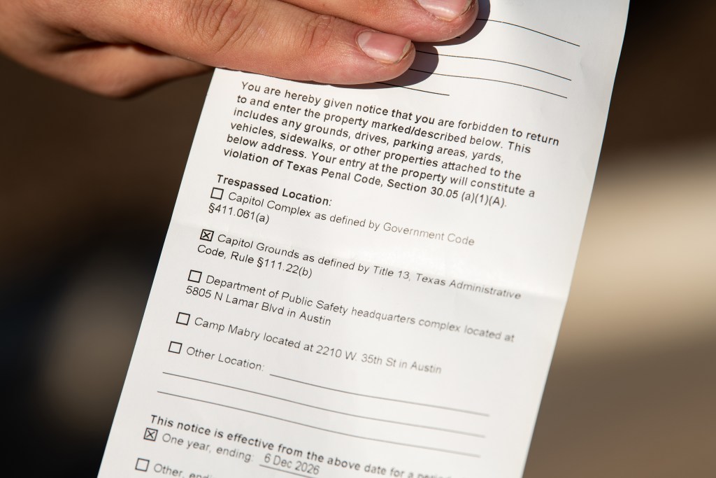 Ry Vazquez shows her criminal trespass warning citation after being detained by Texas Highway Patrol Officers at the Capitol on Saturday. Vazquez is a trans woman and was given a criminal trespass warning and banned from capital grounds for a year. Members of 6W Project protested the newly enacted SB 8 “bathroom bill” by checking what the enforcement measures to enter the bathroom would be at the Capitol. Senate Bill 8, also known as the Texas Women’s Privacy Act, or more commonly known as a “bathroom bill” — aimed at restricting transgender people’s access to certain restrooms in the state, went into effect on December 4, 2025.
