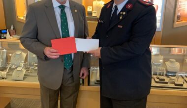 John Rutkowski presents a check for $1,425 to the Salvation Army.