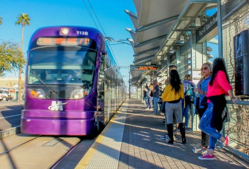 Riders wait for a Valley Metro light rail train.