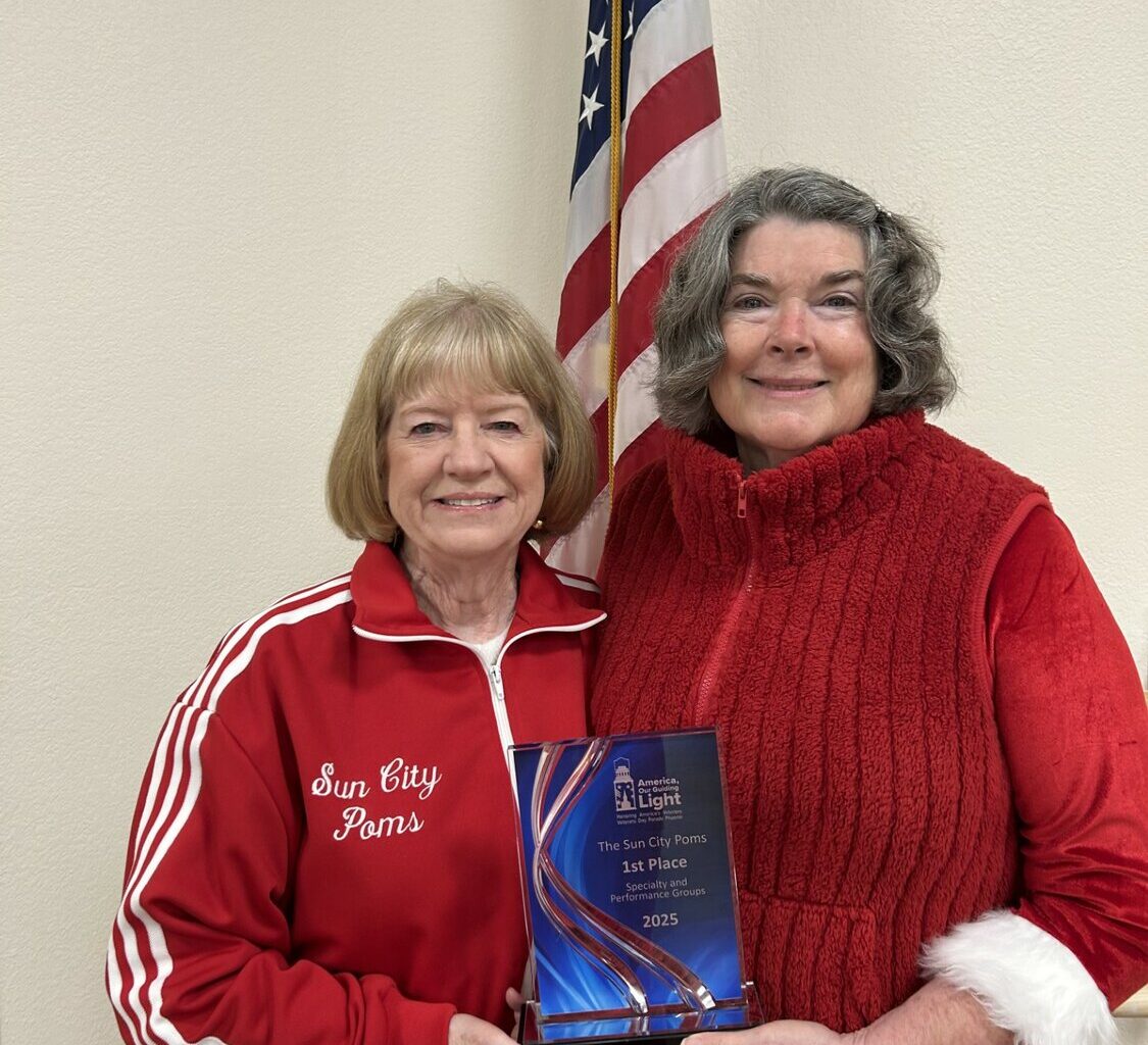 Poms president Sherry Cantrell and marching director Kathy Villa holds the trophy they were awarded.