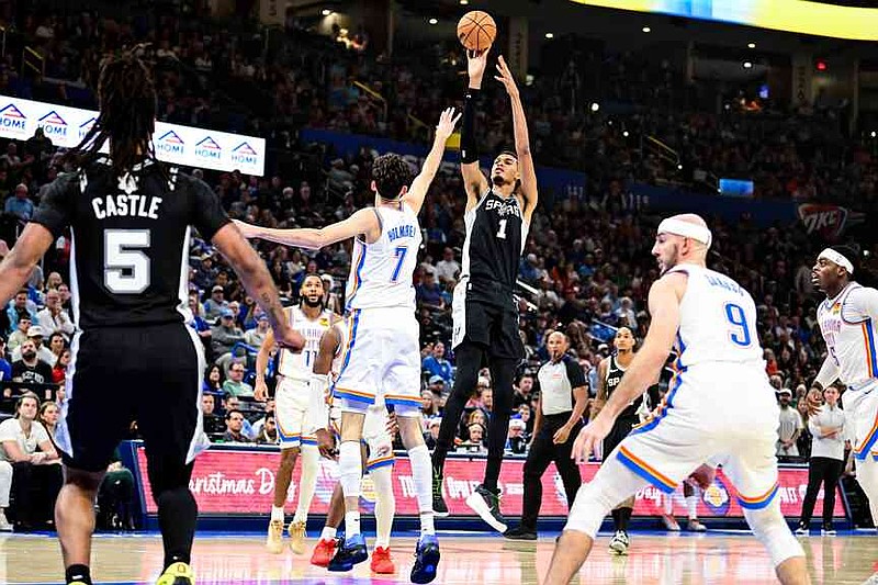 San Antonio Spurs Victor Wembanyama (1) shoots against Oklahoma City Thunder center/forward Chet Holmgren (7) during the first half of an NBA basketball game, Thursday, Dec. 25, 2025, in Oklahoma City. (AP Photo/Gerald Leong)
