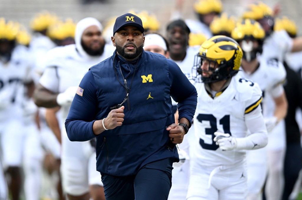 Head coach Sherrone Moore of the Michigan Wolverines leads his team off the field after warm-up before the game against the Maryland Terrapins at SECU Stadium on November 22, 2025 in College Park, Maryland.