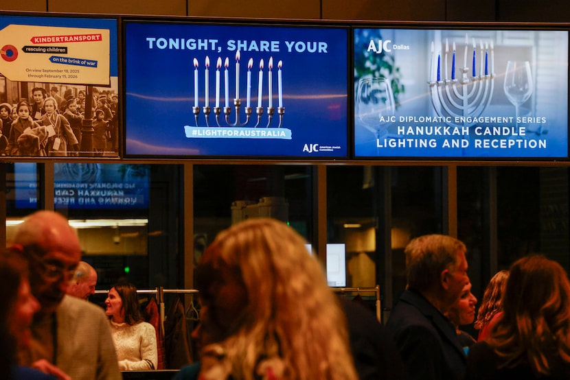 A monitor encourages attendees to share their photos with the hashtag “Light for Australia”...