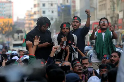 Getty Images Police block the ''March to the Indian High Commission'' program in Dhaka, Bangladesh, on December 17, 2025. The program is organized to demand the repatriation of former Prime Minister Sheikh Hasina, who is ousted from power following the student and public uprising after the July massacre, and others allegedly involved in the killings who are currently staying in India. The protest also condemns ongoing conspiracies by Indian proxies, political parties, media outlets, and government officials. (Photo by Maruf Rahman/NurPhoto via Getty Images)