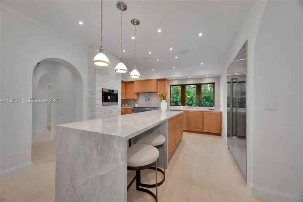 a modern-style kitchen is shown with stainless steel appliances and gray quartz countertops