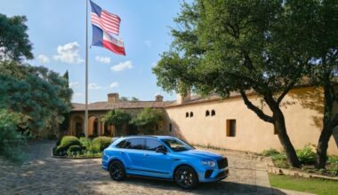 A blue Bentley car is seen parked outside of a home in Texas on a sunny day.