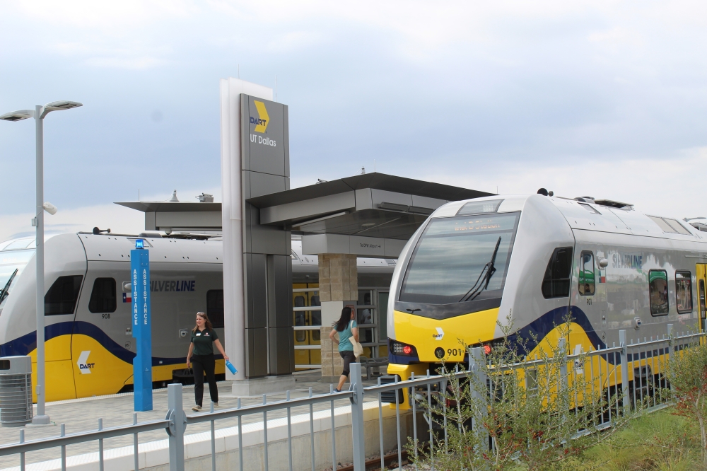 two passenger train cars at a station