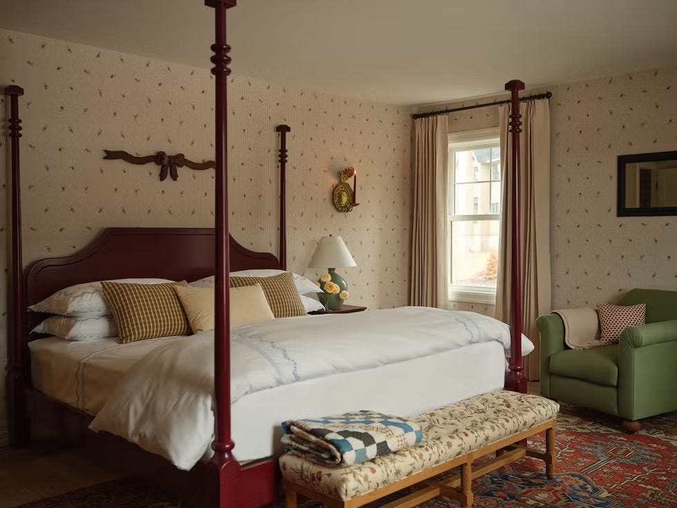 Cozy bedroom featuring a four-poster bed and comfortable seating.