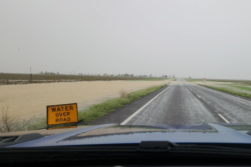 flooded road in Julia creek, water over road sign