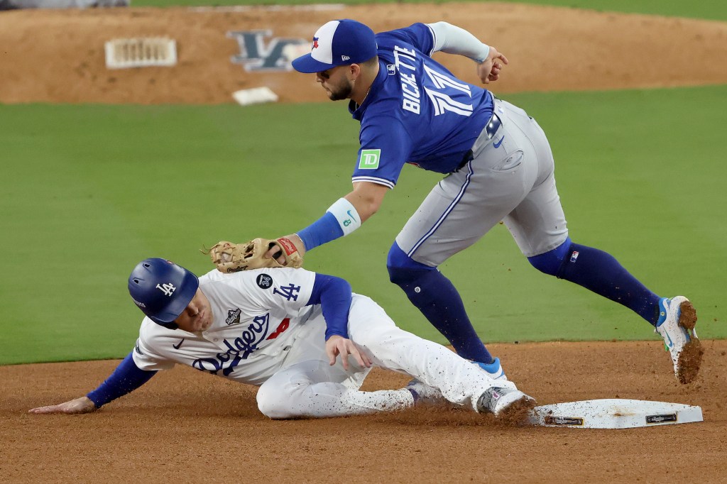 Freddie Freeman of the Los Angeles Dodgers steals second base ahead of Bo Bichette of the Toronto Blue Jays.