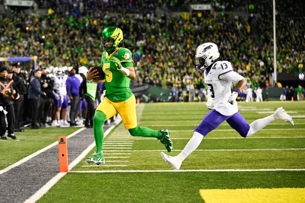 Oregon Ducks quarterback Dante Moore (5) rushing for a touchdown as James Madison Dukes safety Tyler Brown (13) defends.