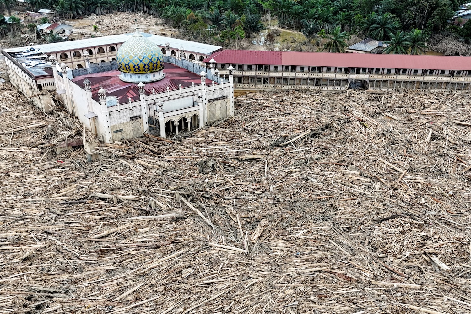 A drone view shows a mosque and a boarding school surrounded by logs carried away during a deadly flash flood in Karang Baru, Aceh Tamiang regency, Indonesia, on Dec 6, 2025. (Photo: Reuters)