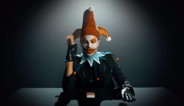 A man in a clown outfit plays with cards.