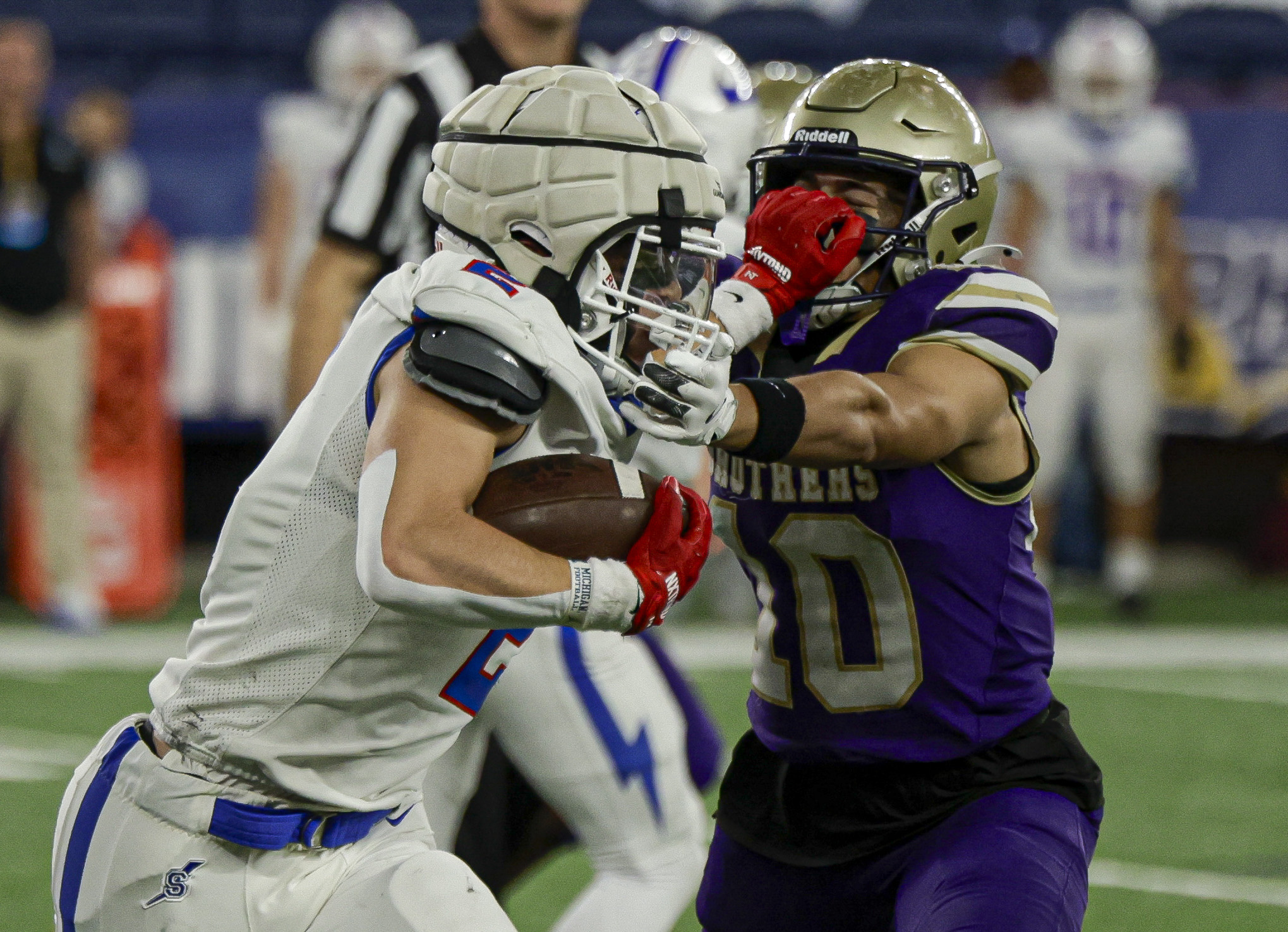 Saratoga Springs Blue Streaks Benjamin Coryea (2) grabs the facemark of CBA Brothers defensive back Tre' Williams (10) on a run as the CBA Brothers and Saratoga Springs Blue Streaks fought for the New York State Class AA state title at JMA Wireless Dome Saturday, December 6, 2025. (N. Scott Trimble | strimble@syracuse.com)