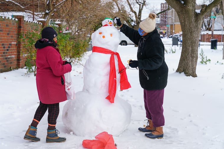 Resdients decorate a snowman near 13th and Thompson Streets in December 2020, the last winter when snowfall was normal in Philly.